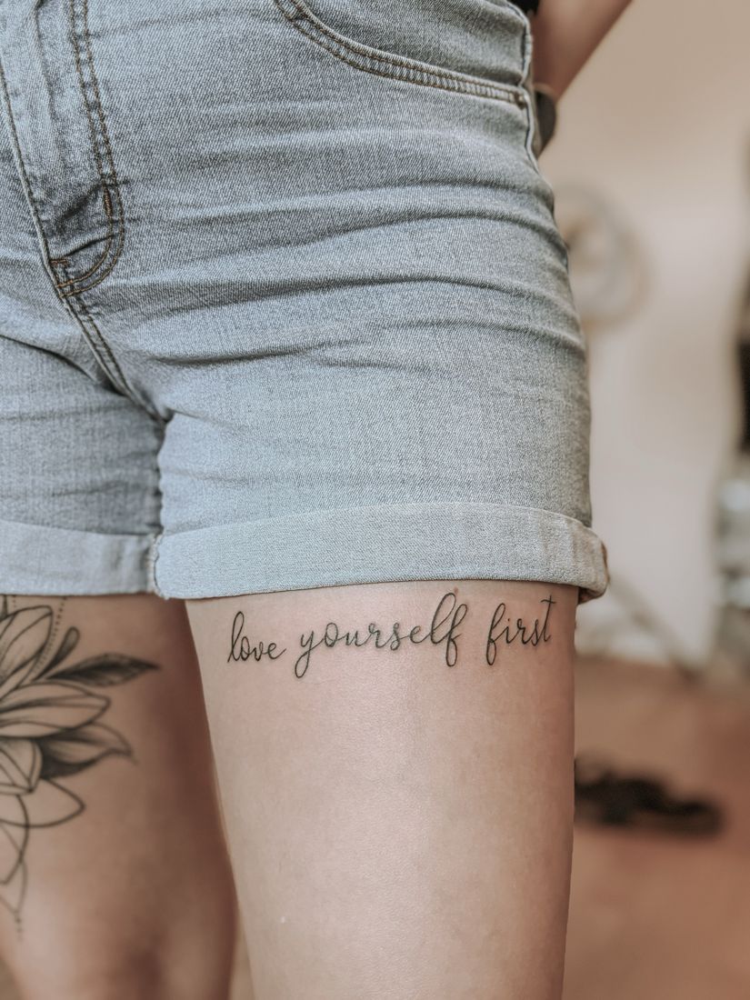 Schriftzug love yourself first am Oberschenkel