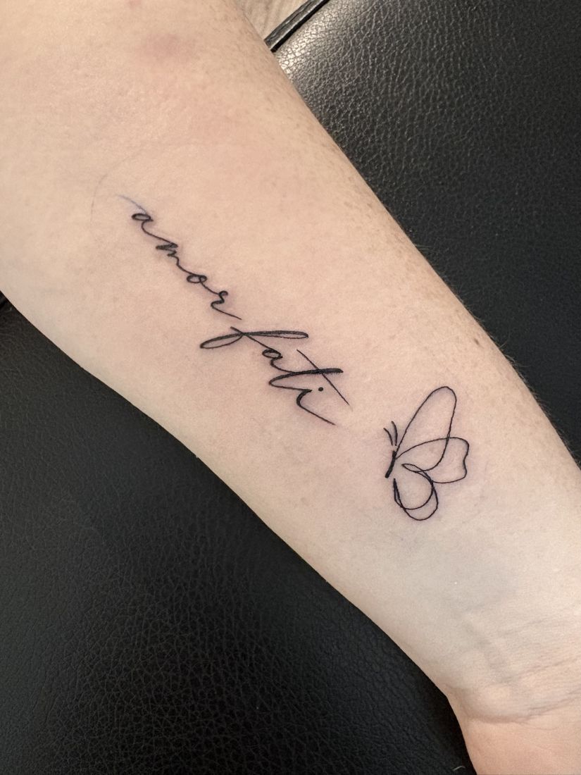 Schriftzug amor fati mit Schmetterling in einer Linie