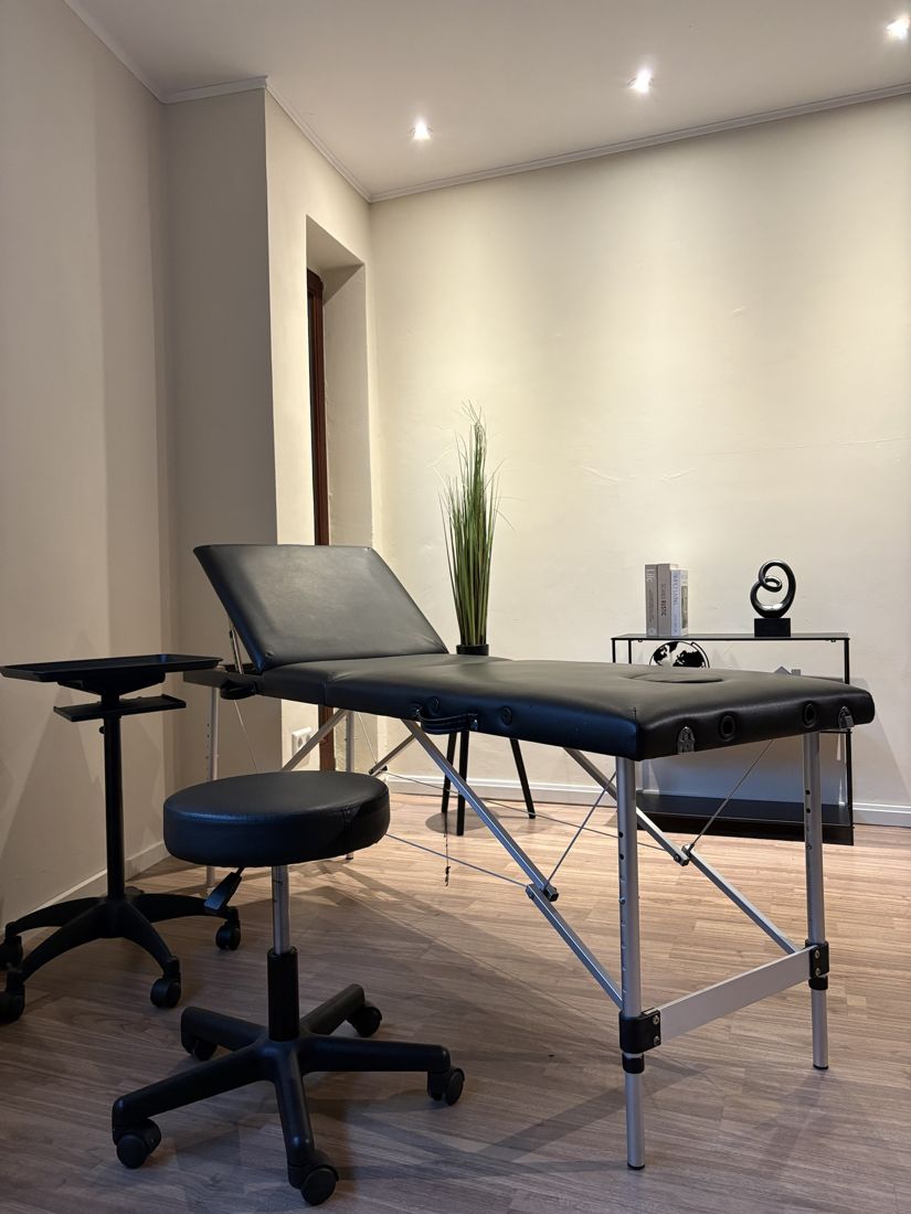 Tattoo-Raum mit schwarzer Liege, Hocker und Arbeitstisch